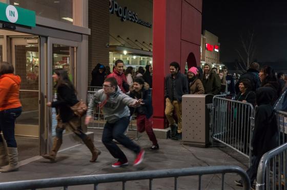 mann l&oslash;per inn i en butikk p&aring; black friday fordi det er store salg. 