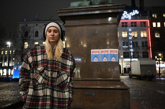 Dyveke Irene Duseth Lunds&aelig;ter foran statue med plakater, p&aring; Stortorvet.