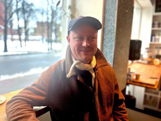 Bildet portretterer en mann, han er leder av bakeriet Mj&oslash;l. Han sitter foran et vindu 