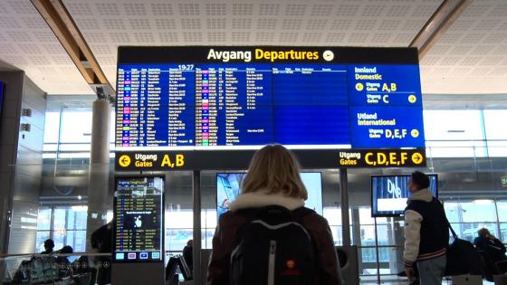 En jente st&aring;r foran en skjerm p&aring; Gardemoen og ser p&aring; gatetidene