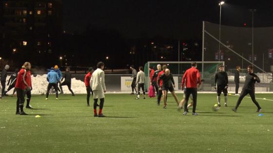 Flere menn l&oslash;per rundt p&aring; en fotballbane. 