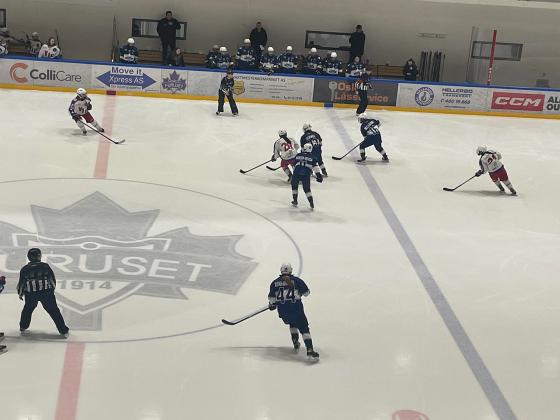 Spillere fra V&aring;lrenga og Furuset spiller ishockey p&aring; banen. Spillerne er i bevegelse med ishockeyk&oslash;ller i h&aring;nda mens de sender pucken frem og tilbake