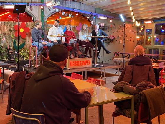 Fem mennesker sitter p&aring; en scene og debatterer. 