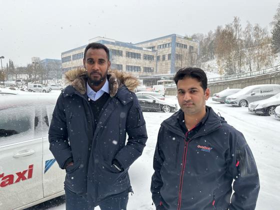 Ismail Shariff og Mohammad Saad st&aring;r i sn&oslash;v&aelig;ret utenfor et bilverksted p&aring; Stovner i Oslo. 