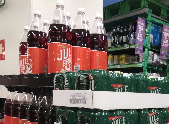 Man ser r&oslash;d julebrud, og bokser med julebrus, stablet opp&aring; hverandre. 