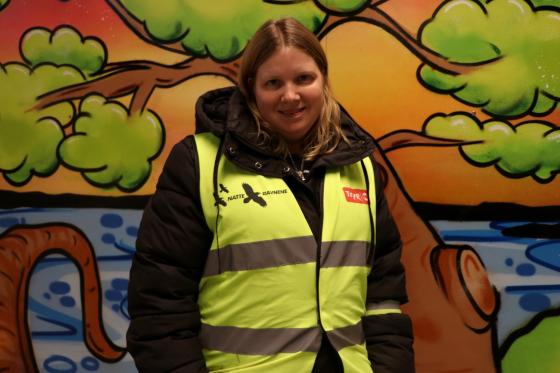 Karianne Skaug foran farget vegg med natteravnvest p&aring; seg