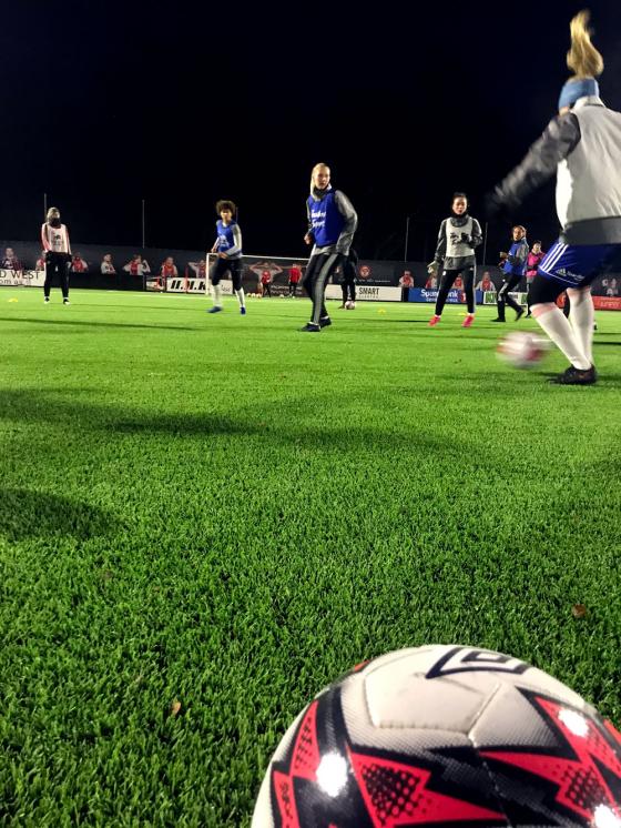 Fotballspillere p&aring; KFUMs kvinnelag st&aring;r med en fotball. Foto: Ida Andersson 