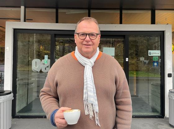 Ottar Nesje st&aring;r med en kaffekopp i h&aring;nda utenfor inngangen p&aring; R&oslash;nningen folkeh&oslash;gskole