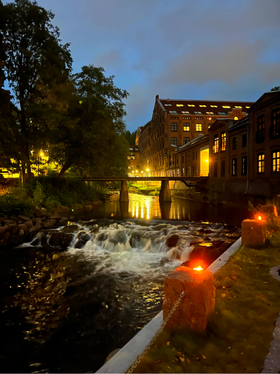 Akerselva p&aring; kvelden med fakler langs siden 