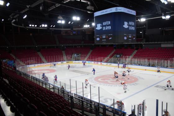 En ishockeybane omringet av r&oslash;de tribune stoler. Det er 11 V&aring;lerenga spillere og 10 Hasle 