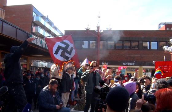 En gruppe motdemonstranter brenner et naziflagg p&aring; T&oslash;yen torg i Oslo. 
