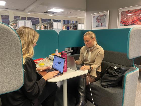 to jenter som sitter og studerer p&aring; biblioteket p&aring; OsloMet.