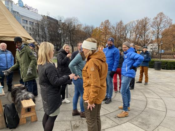 Politikere og representanter fra Norsk Friluftsliv st&aring;r samlet utenfor Stortinget ved en lavo og et bord med kaffe og gl&oslash;gg. 