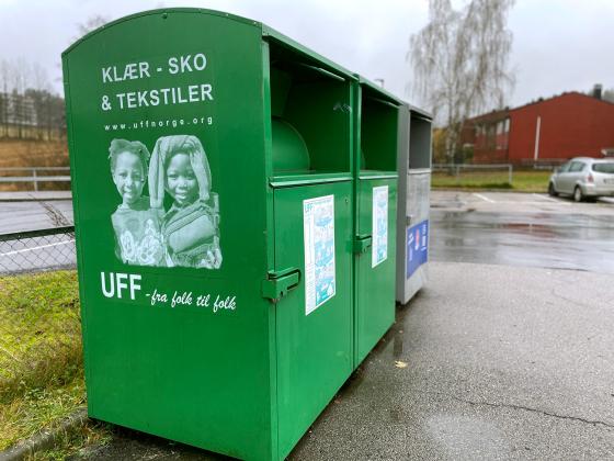 De gr&oslash;nne UFF containeren st&aring;r p&aring; parkeringsplasser utenfor butikker.