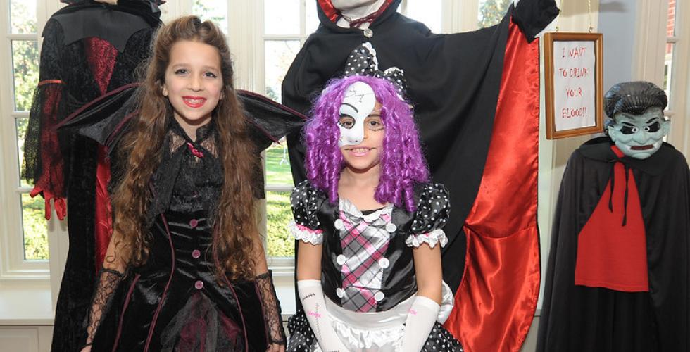 to barn og to voksne har kledd seg ut i halloweenkostymer. De st&aring;r i en gang. 