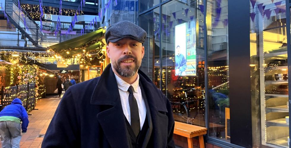 Mikael Diseth st&aring;r mellom to restauranter og smiler skjevt til kamera.