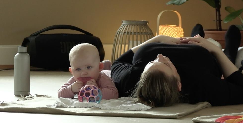 Liten baby sammen med moren sin p&aring; baby-yoga