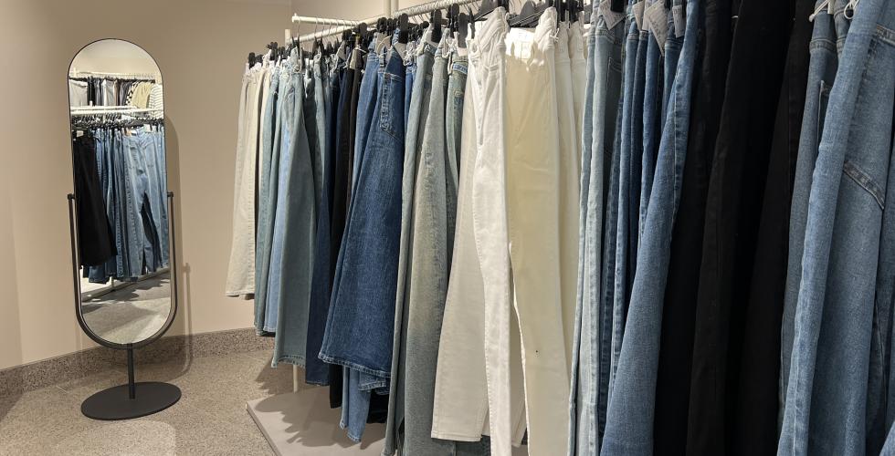 Jeans henger p&aring; kleshengere i butikk