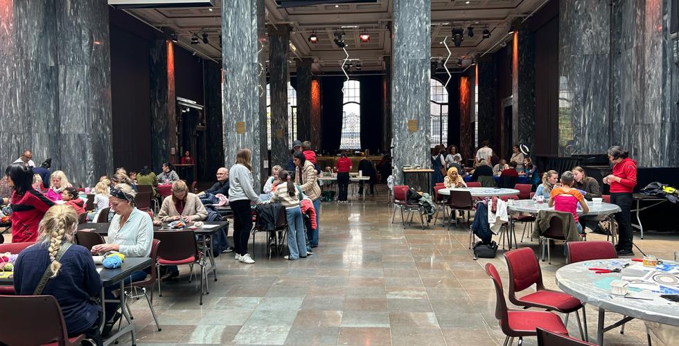 Deltakerne p&aring; H&aring;ndverksdagen p&aring; Sentralen er samlet rundt bord i Marmorsalen hvor de holder p&aring; med ulike typer h&aring;ndverk. 