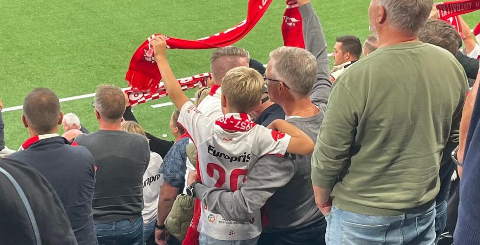Far og s&oslash;nn som holder rundt hverandre p&aring; fotballkamp