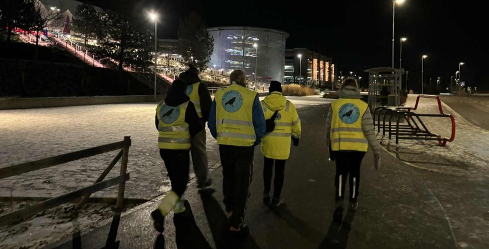 Natteravner med gule refleksvester som g&aring;r i m&oslash;rket