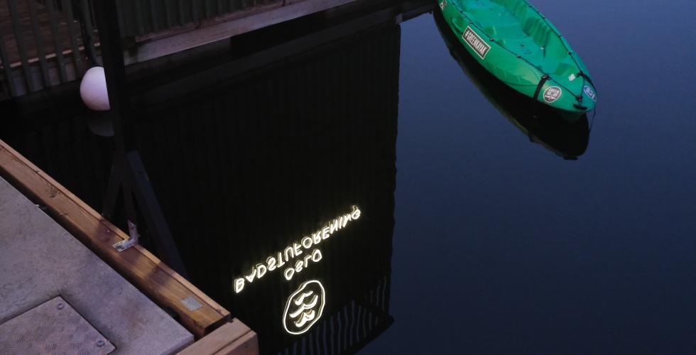 Logoen til Oslo Badstuforening reflekteres i vannet