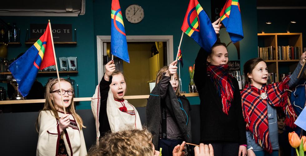 Samiske elever ved Prestvannet skole i Troms&oslash; veiver med samiske flagg.