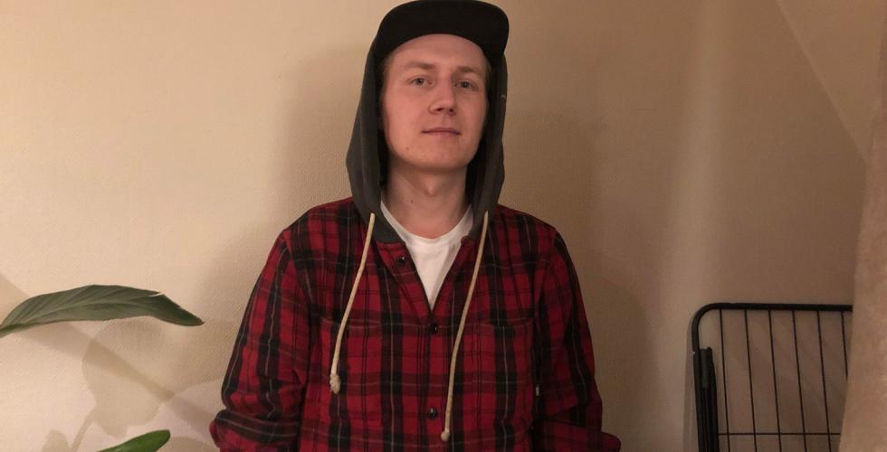 Adrian st&aring;r foran veggen i stuen sin