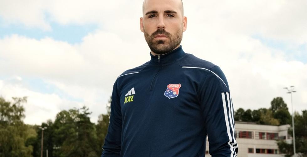 Hovedtrener i Haugerud IF, Alvaro Torres Arjona, poserer i treningsoverdel p&aring; en fotballbane. 