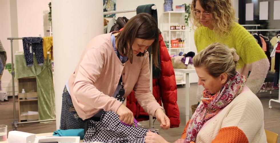 Medlemmer fra RELOVE og daglig leder for bruktbutikk p&aring; Holmlia ler og koser seg mens de arbeider