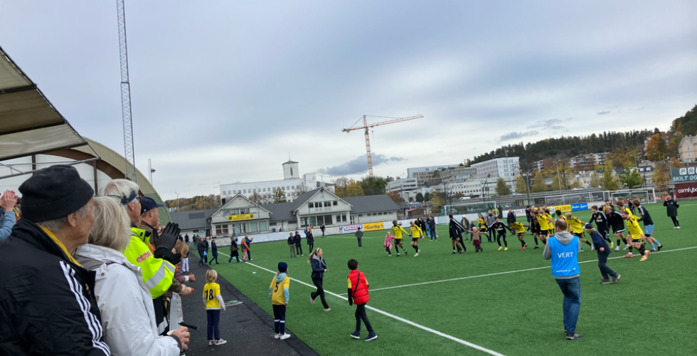 Bilde fra Sandvika Stadion. B&aelig;rum sine alagsspillere er stilt opp p&aring; rekke, holder hverandre i hendene, og er p&aring; vei til &aring; gj&oslash;re den s&aring;kalte b&oslash;lgen overfor gjenv&aelig;rende fans p&aring; tribunen etter kampen mot Tr&aelig;ff.