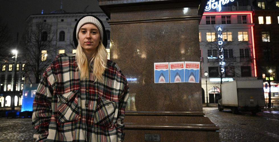 Dyveke Irene Duseth Lunds&aelig;ter foran statue med plakater, p&aring; Stortorvet.