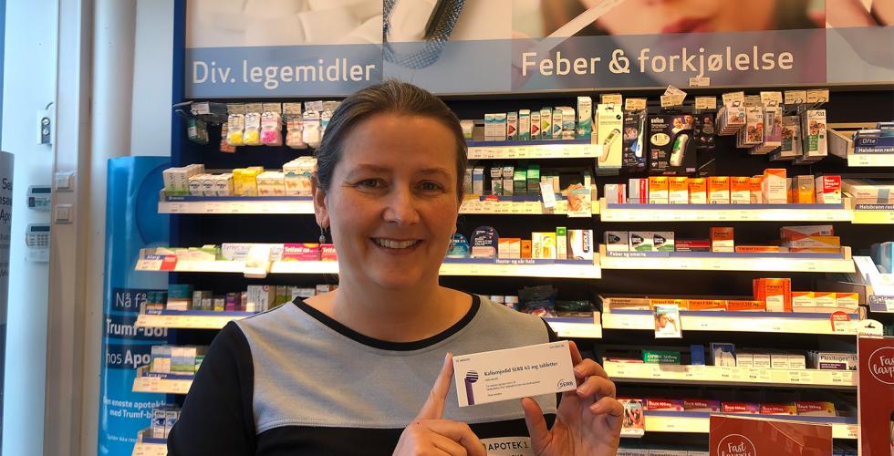 En farmasoyt holder en pakke med jod-tabletter p&aring; apoteket