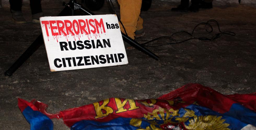 Skilt p&aring; markerin mot Russland som oversettes til "Terrorismen har Russisk statsborgerskap". 