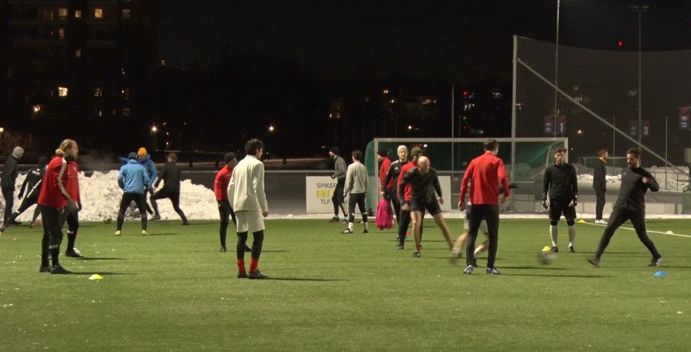 Flere menn l&oslash;per rundt p&aring; en fotballbane. 