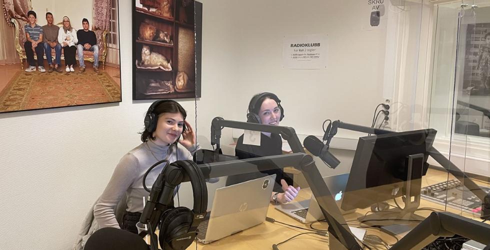 Programlederne sitter klare i studio til &aring; lede lytterne gjennom en sending om pengeprat. 