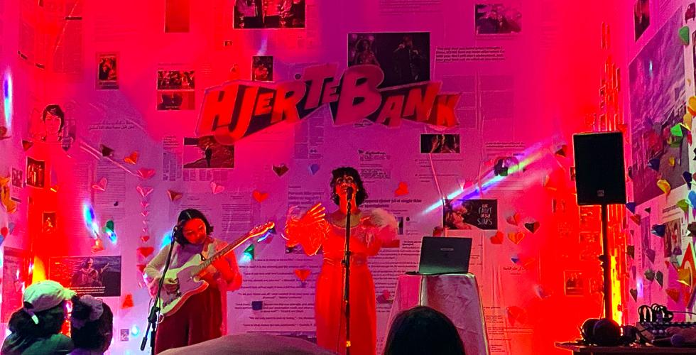 Pop duoen filthy burger girl som st&aring;r p&aring; scenen og fremf&oslash;rer i utstillingen Hjertebank. 