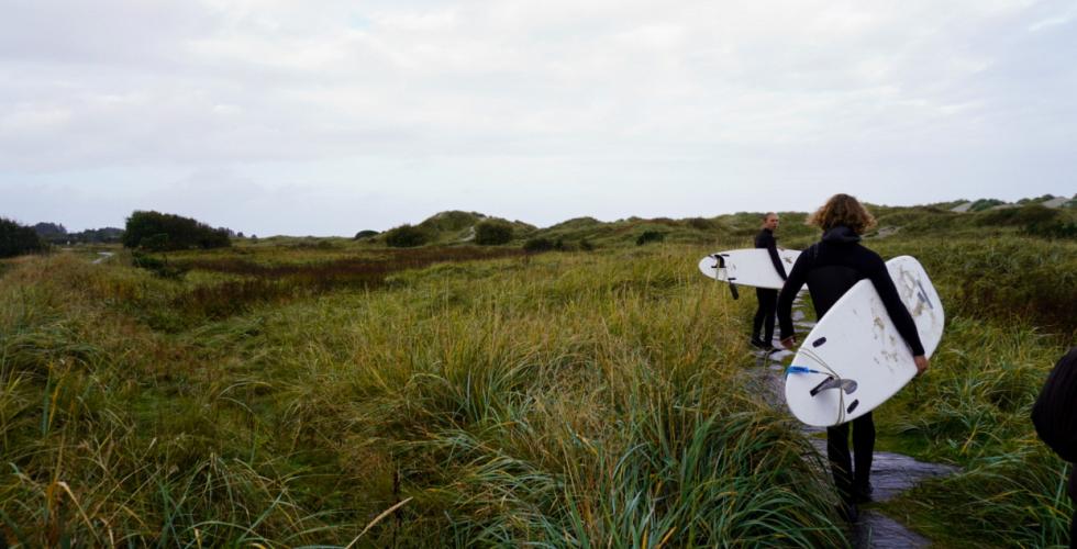 Mikael (20) og Lars (22) er p&aring; vei til stranden med surfebrettene sine.