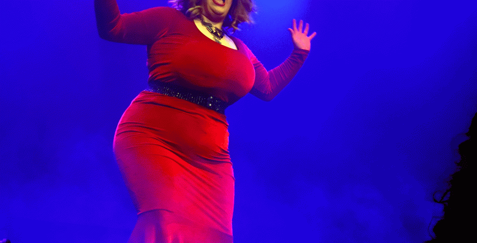 Dragartisten Monetta Leone syng p&aring; scena i raud kjole. 