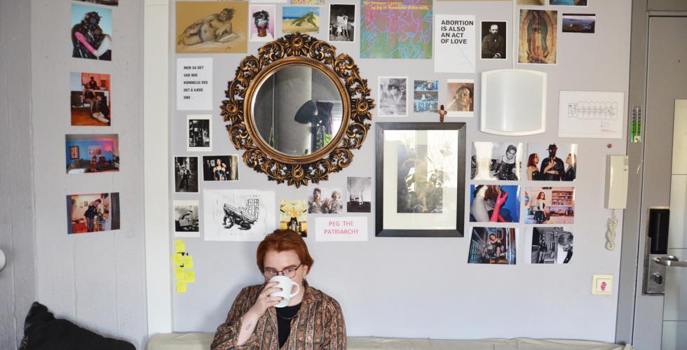June Kittelsen sitter i senga p&aring; hybelen sin med en kaffekopp
