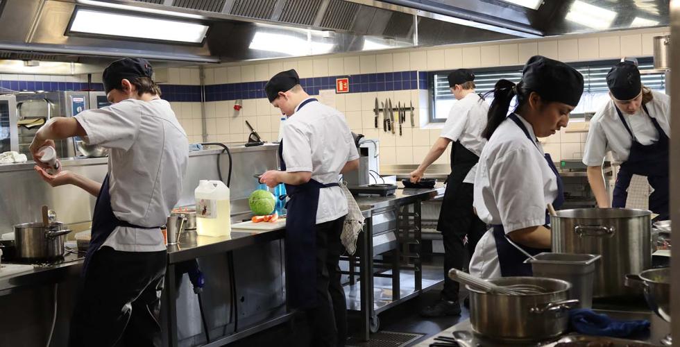 Elevene ved restaurant- og matfag under praktisk undervisning p&aring; kj&oslash;kkenet