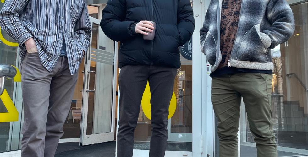 Tre unge menn st&aring;r foran inngangen til en bygning p&aring; Oslomet