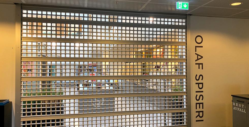 Gitterd&oslash;rer over inngangen til kantina ved Pilestredet 35