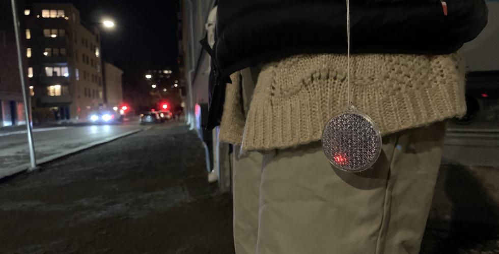 Refleks som henger ut av en lomme i en m&oslash;rk gate.