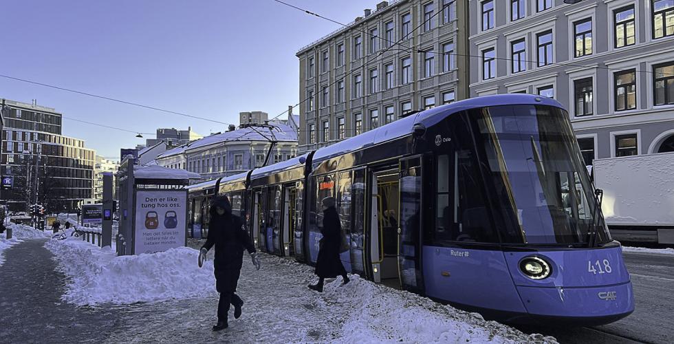 Trikk i sn&oslash; med sol p&aring; himmelen