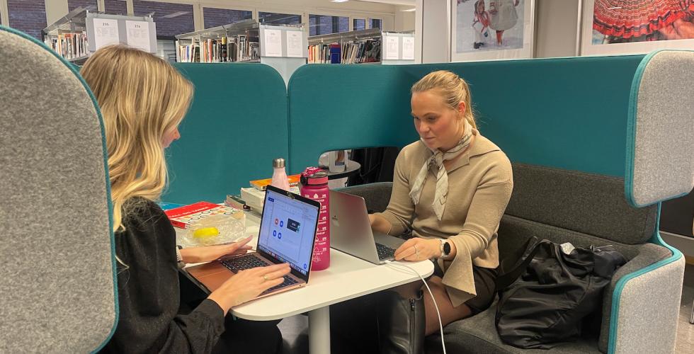 to jenter som sitter og studerer p&aring; biblioteket p&aring; OsloMet.