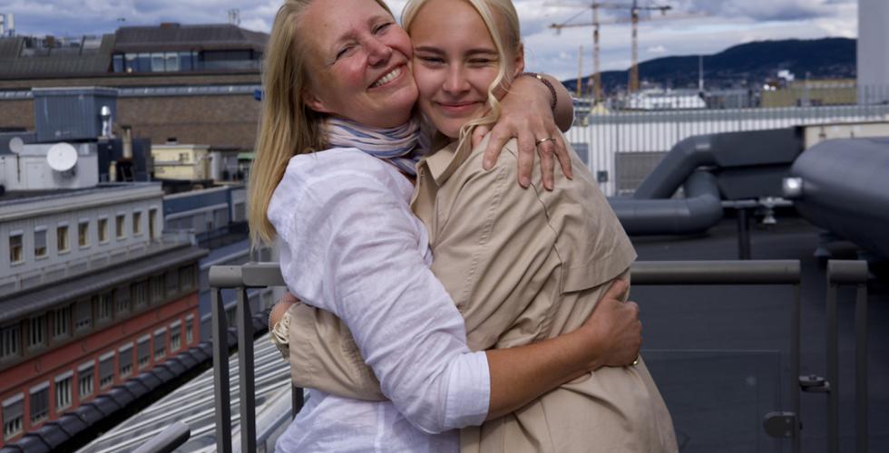 Artisten Thea Marlene og moren omfavner hverandre p&aring; en takterasse med utsikt ut over Oslo