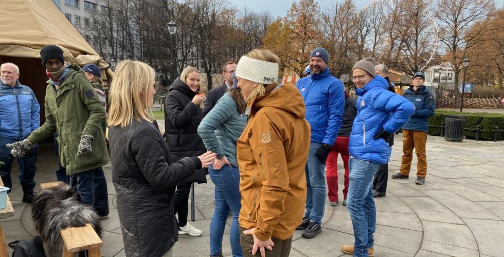 Politikere og representanter fra Norsk Friluftsliv st&aring;r samlet utenfor Stortinget ved en lavo og et bord med kaffe og gl&oslash;gg. 