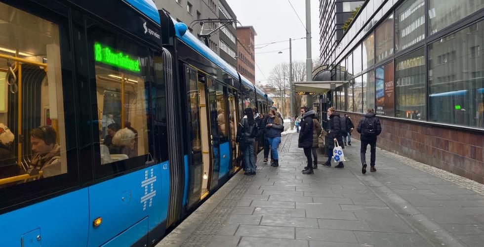Bilde av et trikkestopp hvor mennersker g&aring;r inn p&aring; trikken.