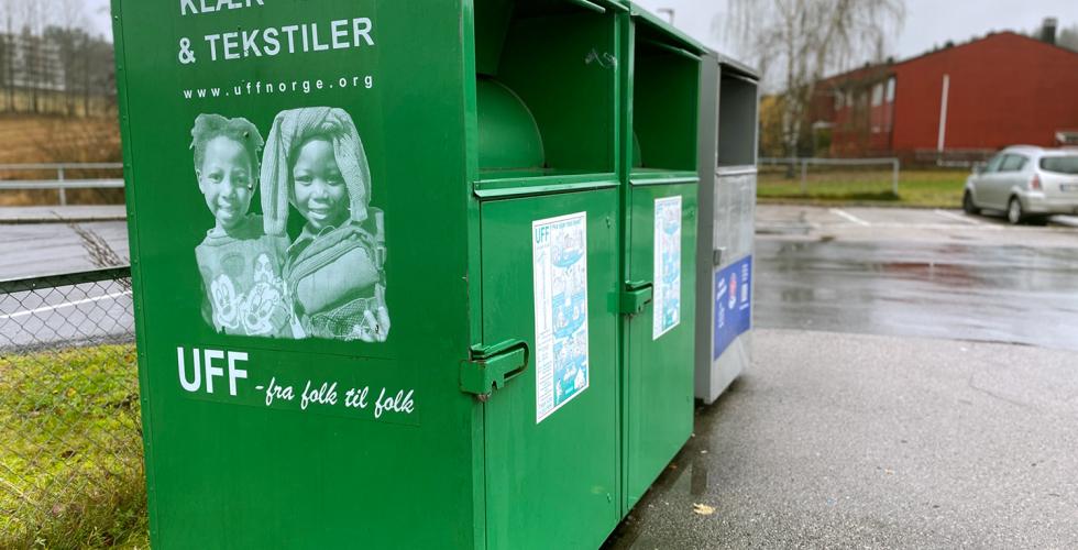 De gr&oslash;nne UFF containeren st&aring;r p&aring; parkeringsplasser utenfor butikker.